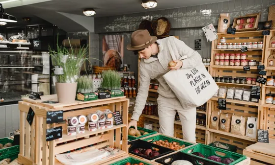 A man shopping with a goodbag sustainable tote bag at a zero-waste store