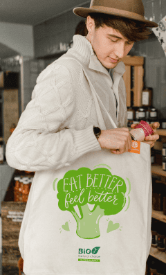 Mann schaut in eine goodbag mit dreifarbigem Siebdruck und dem Aufdruck „EAT BETTER – feel better“