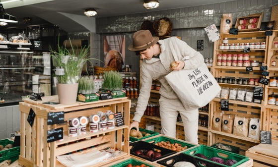 Um homem fazendo compras com uma sacola tote sustentável goodbag em uma loja sem desperdício