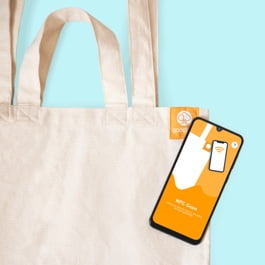 Uma foto de uma sacola tote sustentável goodbag sendo escaneada com um telefone NFC